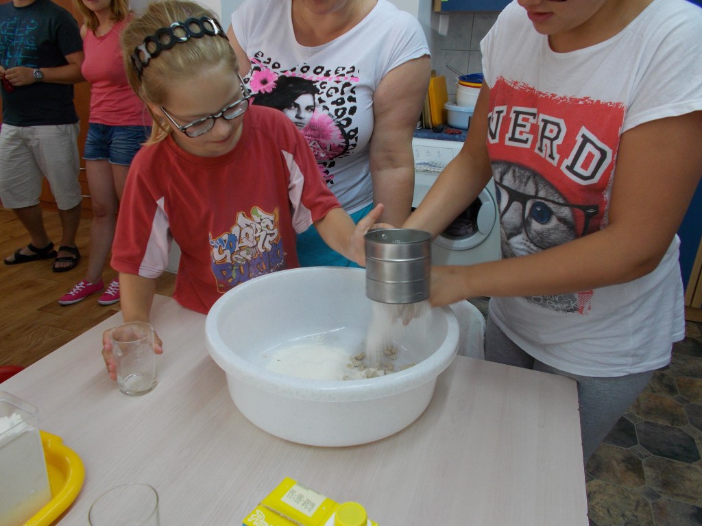 Marcela przesiewa mąkę przez sitko